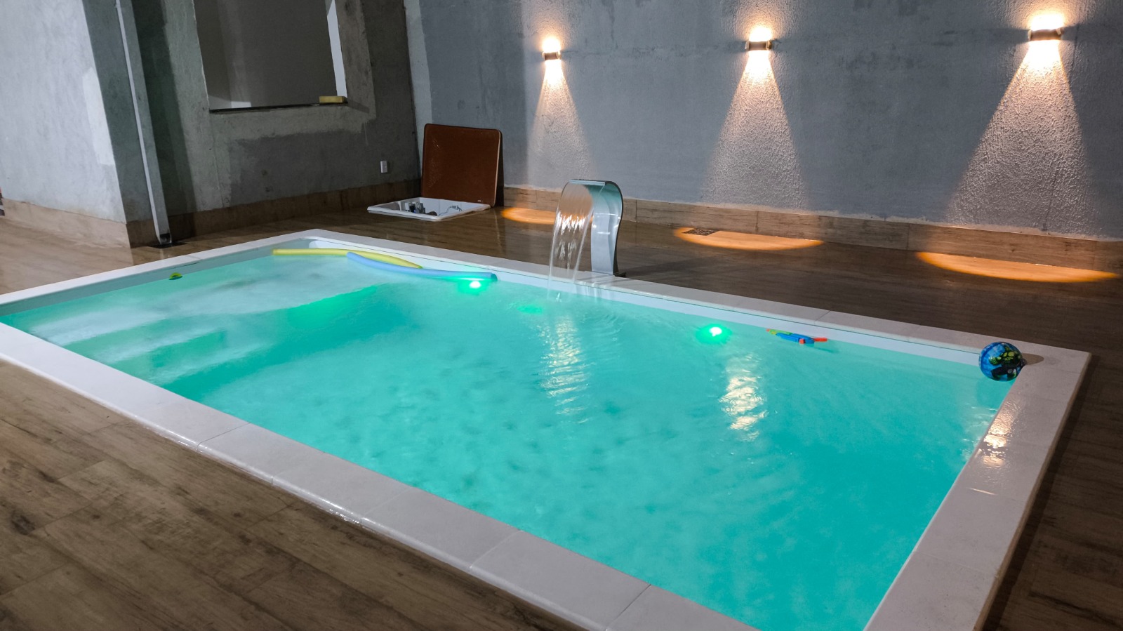 Spa iluminado à noite com cascata