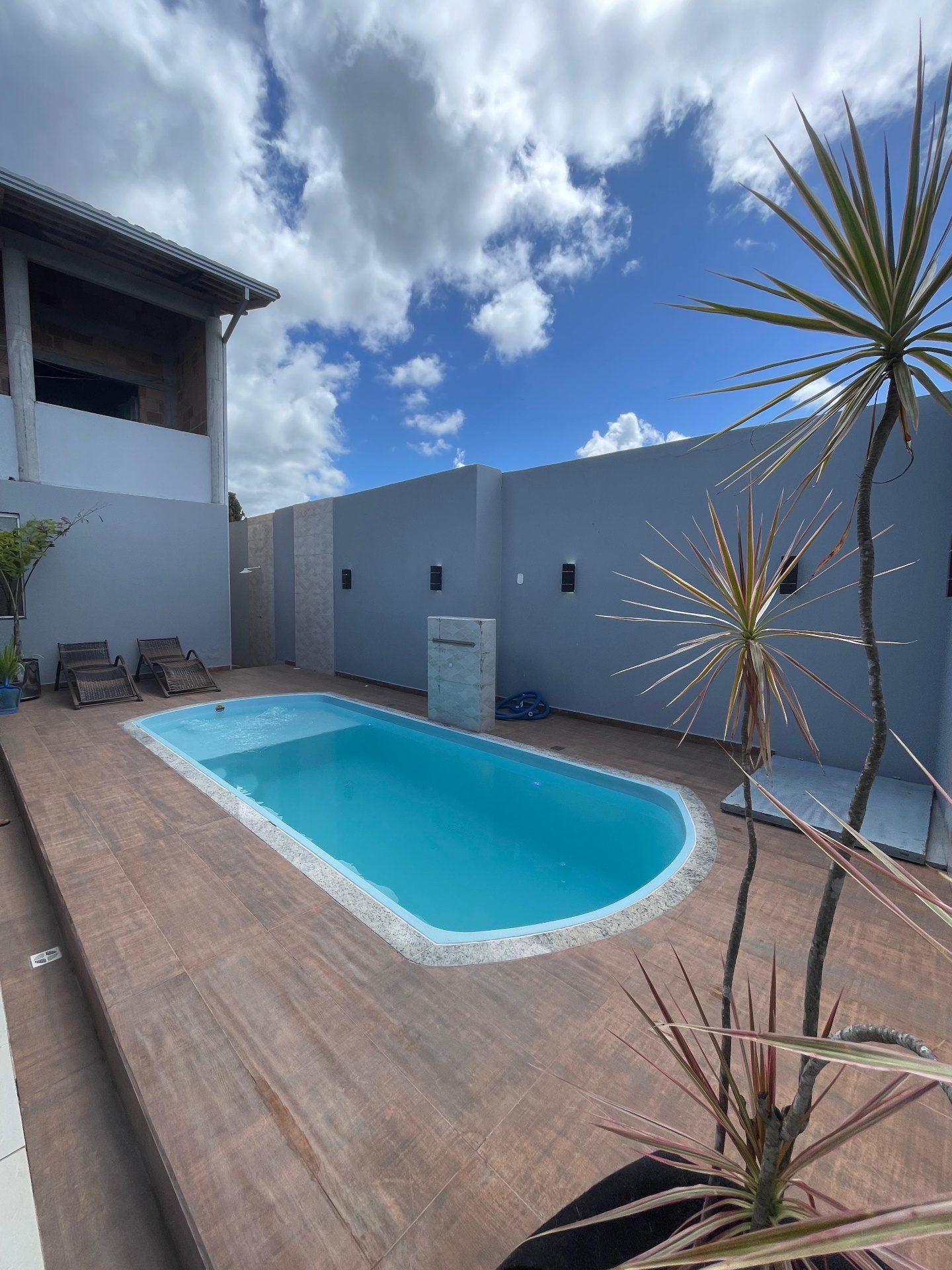 Piscina residencial alongada com céu aberto ao fundo